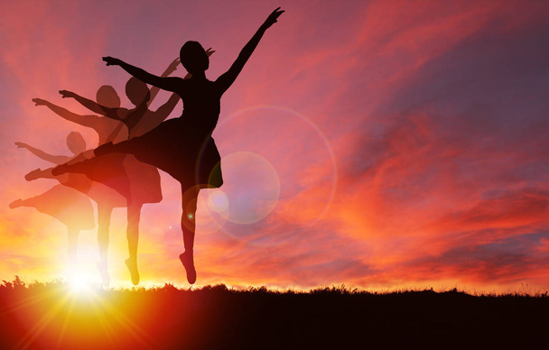 Silhueta de meninas dançando e pulando com vibrante nascer do sol dourado ou pôr do sol fundo e espaço de cópia. Conceito de vida saudável, exercício, celebração ou humor jubilante
. - Foto, Imagem