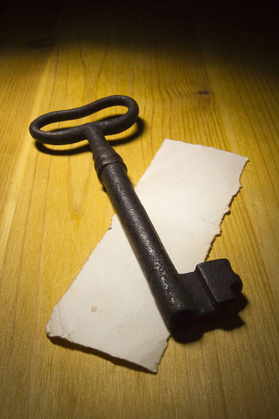 Old rusty key on a wooden table - Foto, imagen