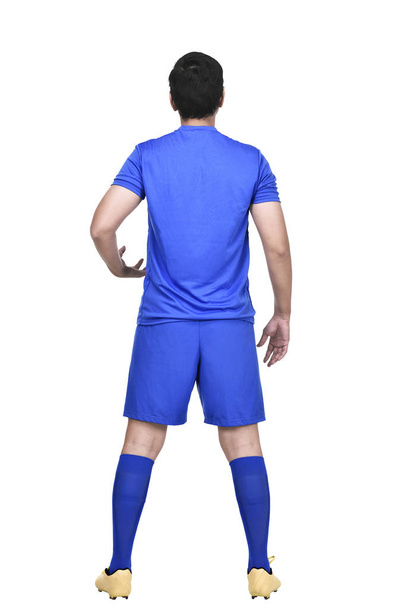 Rear view of asian soccer player in blue jersey standing isolated over white background - Zdjęcie, obraz