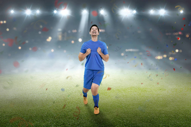 Young asian footballer man with happy expression on the field - Photo, image