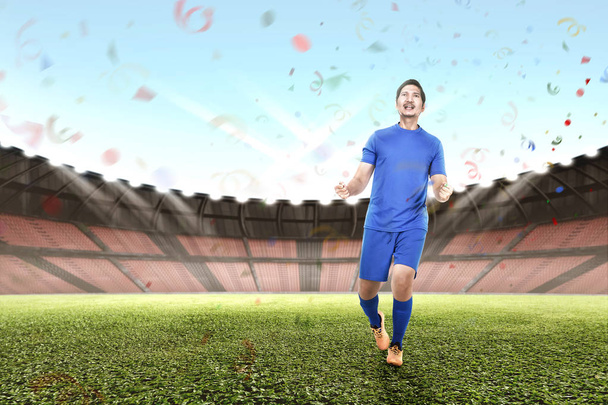 Професійний азіатський футболіст святкує свою перемогу на стадіоні
 - Фото, зображення