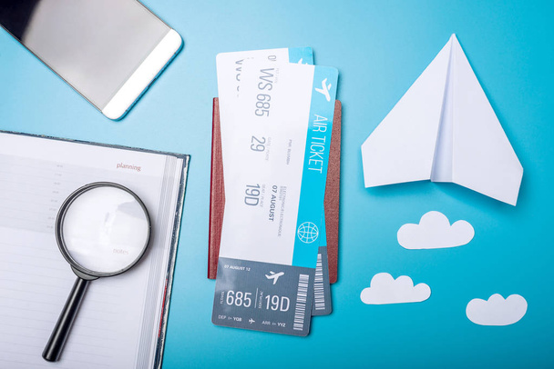 Billets d'avion avec passeport et avion en papier sur fond bleu, vue de dessus. Fond Pastel lumineux. Le concept de voyage et de vacances en avion
 - Photo, image