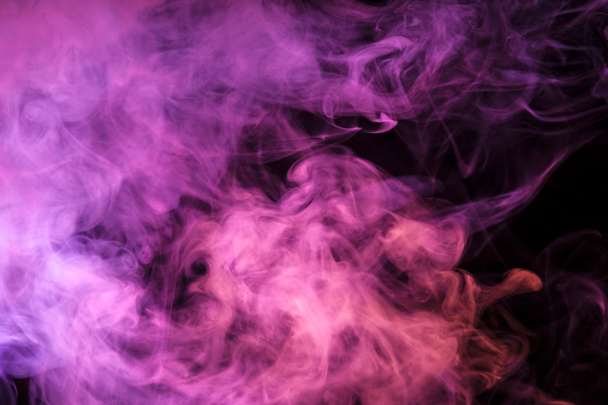 Dikke kleurrijke rook van roze, oranje, blauw op een geïsoleerde zwarte achtergrond. Achtergrond van de rook van vap - Foto, afbeelding