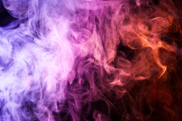 Espeso humo de color rosa y naranja sobre un fondo negro aislado. Antecedentes del humo del vap
 - Foto, imagen