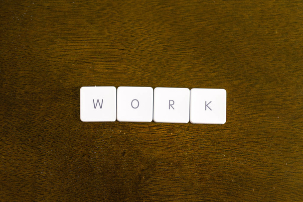WORK word written on plastic keyboard alphabet with dark background - Fotó, kép