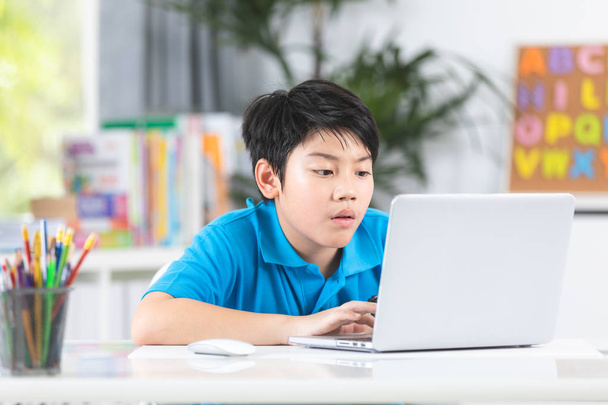 Asian cute boy using laptop computer. - Фото, изображение