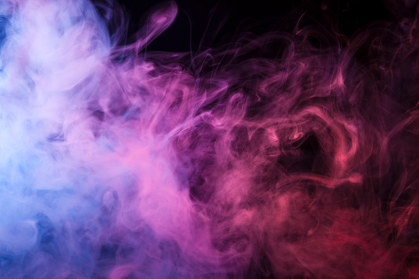 Colorful pink,red and blue smoke  on a black isolated background. Background from the smoke of vap - Photo, Image