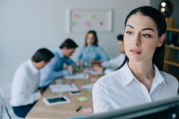 focalizzazione selettiva di donne d'affari pensose e colleghi dietro a posto di lavoro in ufficio
 - Foto, immagini