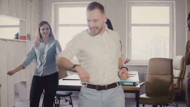 Kaukaski młody mężczyzna executive robi śmieszne zwycięstwo taniec o zabawy dorywczo office strony, świętować osiągnięcie biznesowe 4k - Materiał filmowy, wideo
