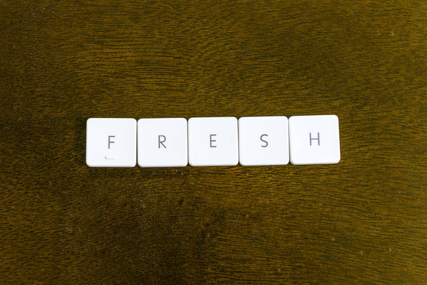 Слово FRESH, написане на пластиковій клавіатурі з темним тлом
 - Фото, зображення