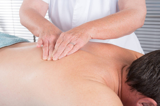 Чоловік має масаж спини в оздоровчому центрі
 - Фото, зображення