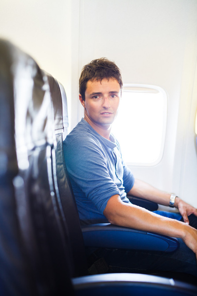 Красивый молодой человек на борту самолета во время полета, смотри
 - Фото, изображение