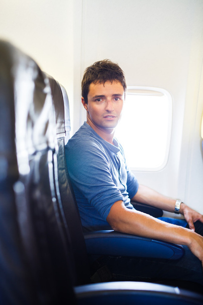 Красивый молодой человек на борту самолета во время полета, смотри
 - Фото, изображение