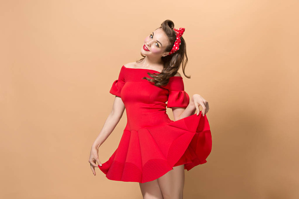 Beautiful young woman with pinup make-up and hairstyle. Studio shot on pastel background - Foto, Imagen