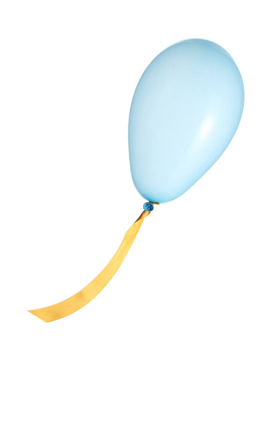 licht blauwe partij ballon met een geel lint geïsoleerd op een witte achtergrond met uitknippad - Foto, afbeelding