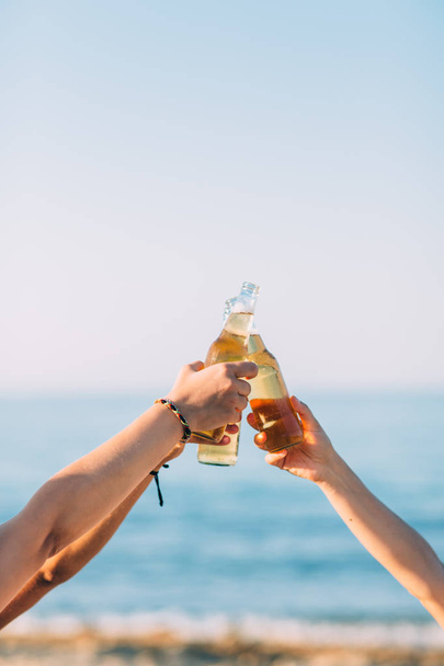 three hands holding and cheers with beer bottles  - Photo, Image