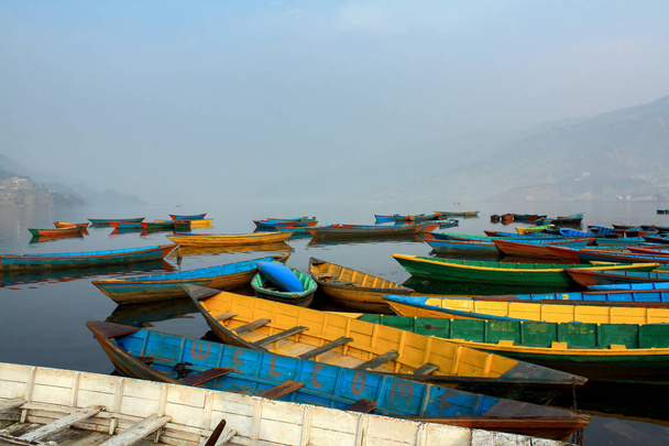 Colorful boats symbol of Phewa lake shore with fog in the morning ,Pokhara Nepal. - Photo, Image