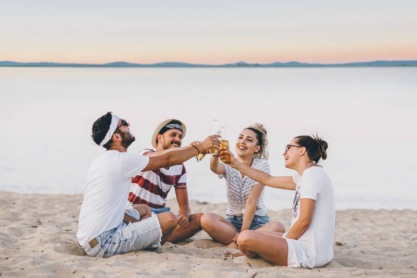 Group of young friends celebrating with beer on beach - Φωτογραφία, εικόνα