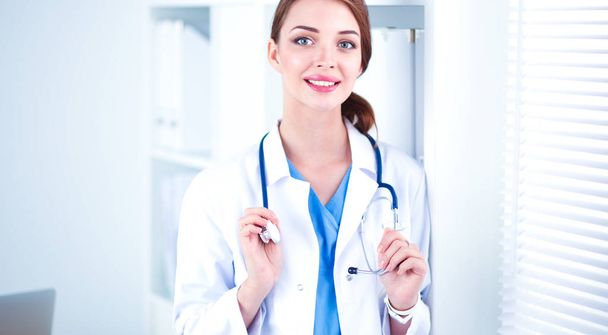 Portrait of happy successful young female doctor holding a stethoscope - Fotó, kép