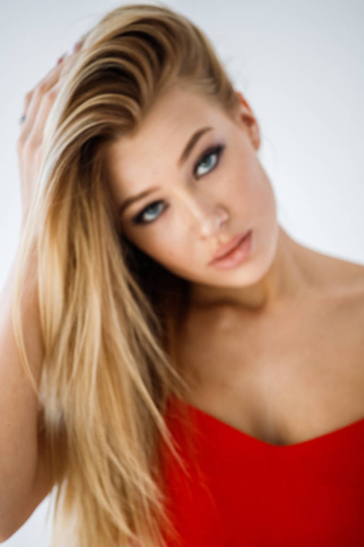 Closeup studio portrait of lovely blonde girl in red clothes on white background - Φωτογραφία, εικόνα