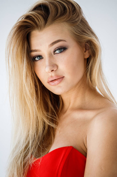 Closeup studio portrait of lovely blonde girl in red clothes on white background - Photo, Image