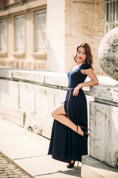 A beautiful girl in a dress is walking around the city - Zdjęcie, obraz