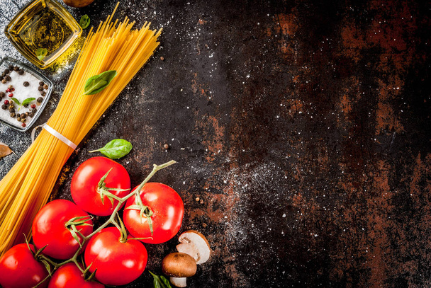 Lebensmittel Hintergrund, Zutaten zum Kochen Abendessen. Nudelspaghetti, Gemüse, Soßen und Gewürze, dunkel rostiger Hintergrund Kopierraum von oben - Foto, Bild