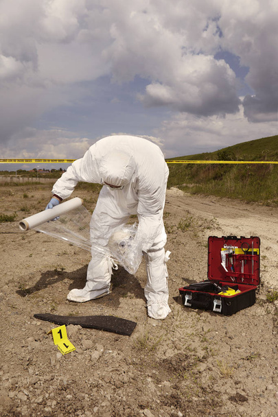 Police technician packing human skull found on plain construction yard during work - Foto, Bild