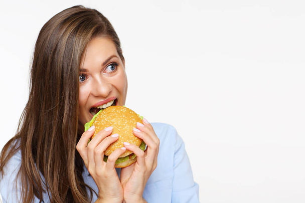 portrait of hungry businesswoman in blue shirt eating burger  - Foto, afbeelding