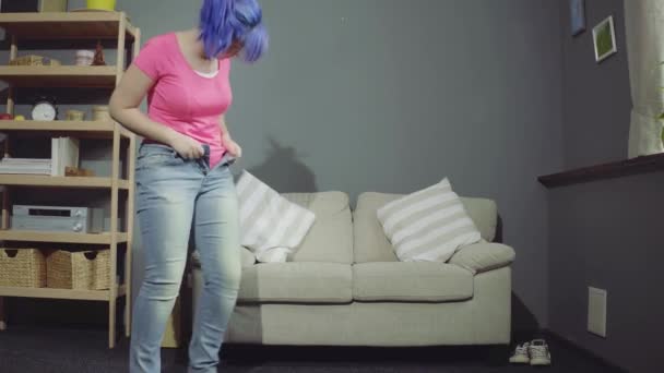 Beautiful girl is trying to put on jeans - Záběry, video