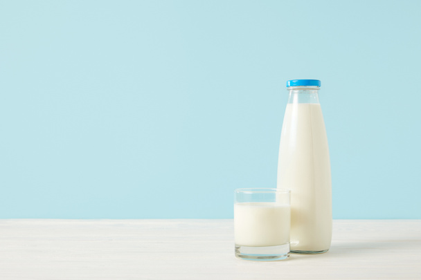 Közelkép kép palack tej és a tej üveg-kék háttér  - Fotó, kép
