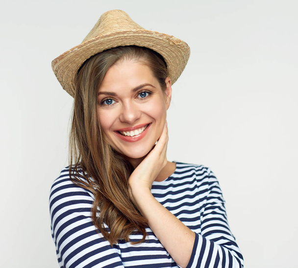 portrait of smiling woman wearing hat and striped shirt looking at camera  - Zdjęcie, obraz