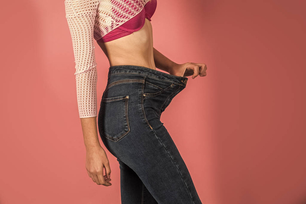 Slim waist of young female in big jeans - Φωτογραφία, εικόνα