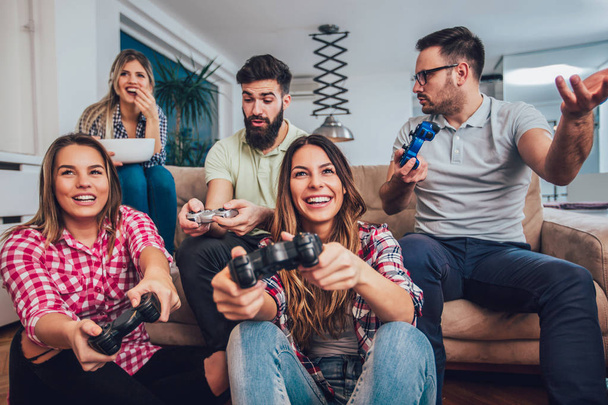 Група друзів, які грають у відеоігри вдома
 - Фото, зображення