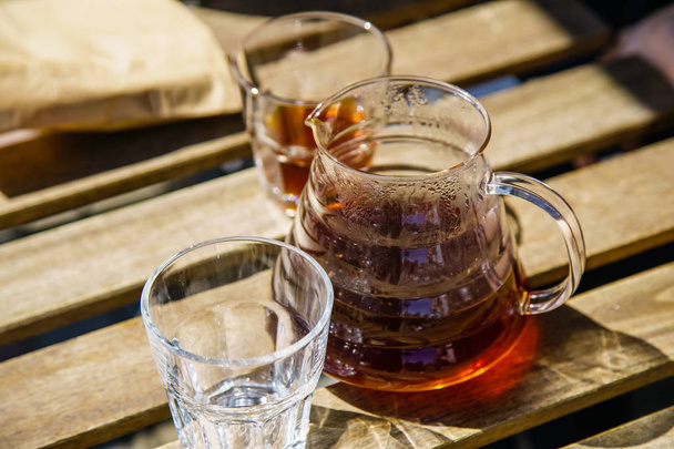 Glass pot with alternatively brewed coffee at the sunny street cafe on wooden table  - 写真・画像