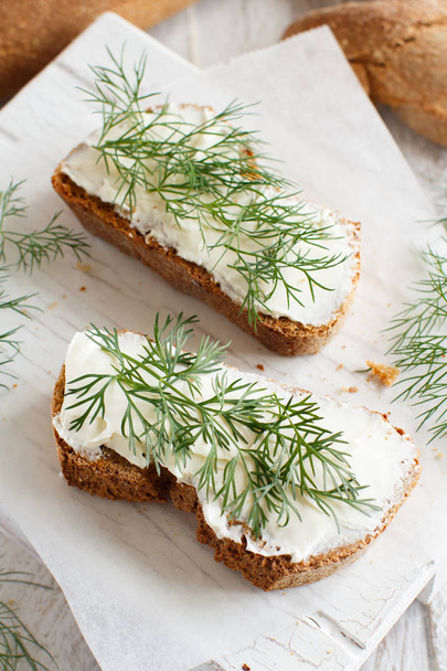Sandwiches with cream cheese and fresh dill on a wooden table - Photo, Image