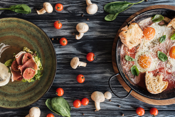 木製のテーブルに美味しい生ハム、卵焼き、新鮮な野菜のトップ ビュー - 写真・画像