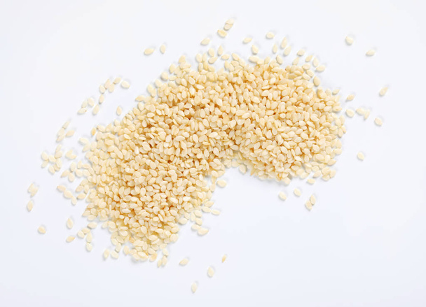 pila de semillas de sésamo saludables sobre fondo blanco
 - Foto, imagen