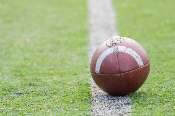 Leather football ball lying on green field - Zdjęcie, obraz