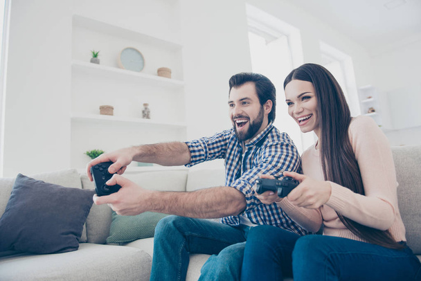 Portrait of cheerful active couple enjoying playing videogame on playstation in house holding console gamepad in hands, fans of xbox - Photo, Image