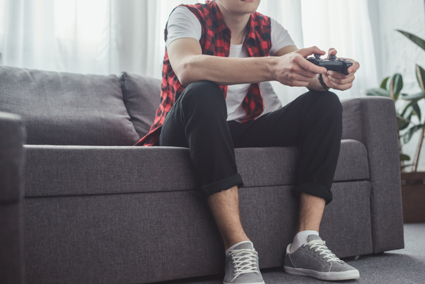 cropped view of man playing video game with joystick at home - Foto, Bild