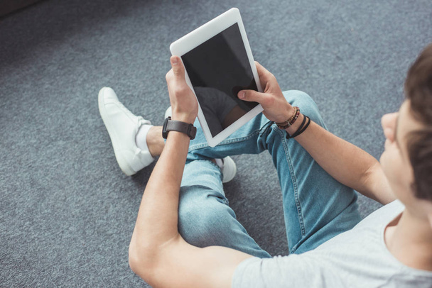 young man using digital tablet with blank screen while sitting on floor - Φωτογραφία, εικόνα