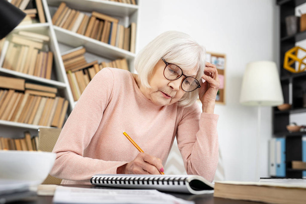 Troubled mature woman cramming material - Photo, Image