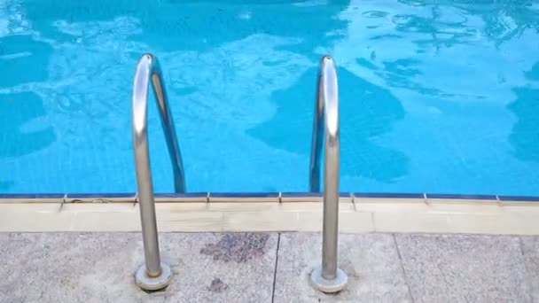 Ocelové zábradlí a textury modrou vodu v bazénu hotelu - Záběry, video