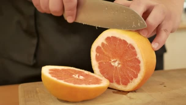 Manos de hombre cortando naranja fresca
 - Metraje, vídeo