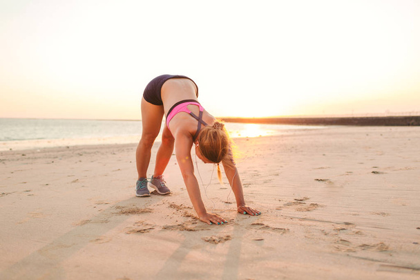 atletka cvičení na písečné pláži s výhledem na moře za - Fotografie, Obrázek