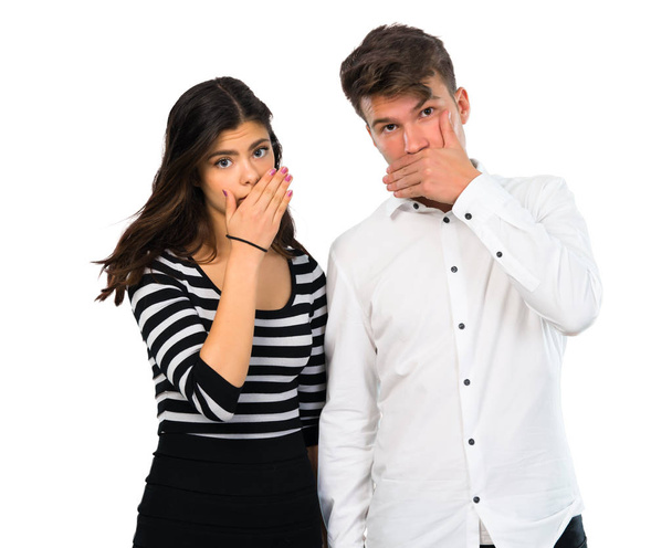 Jeune couple couvrant la bouche avec les mains sur fond blanc isolé
 - Photo, image