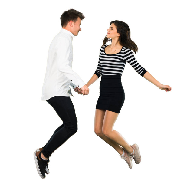 junges Teenager-Paar springt auf isoliertem weißen Hintergrund - Foto, Bild