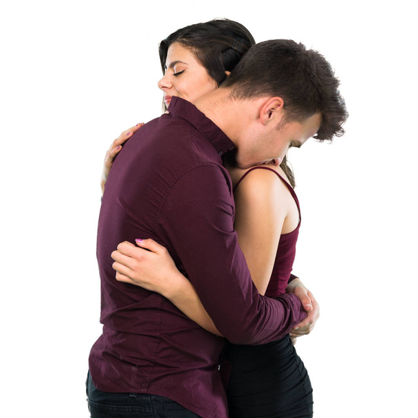 Young teenager couple hugging on isolated white background - Photo, image