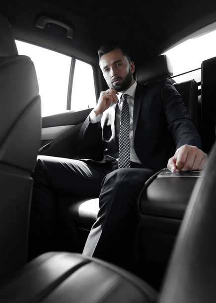 Successful businessman sitting in the back seat of a car - 写真・画像